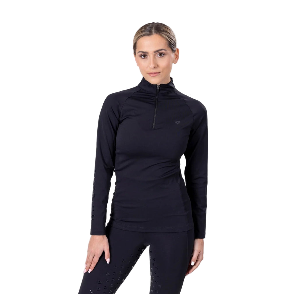 Woman wearing a black long-sleeve equestrian base layer top on a white background