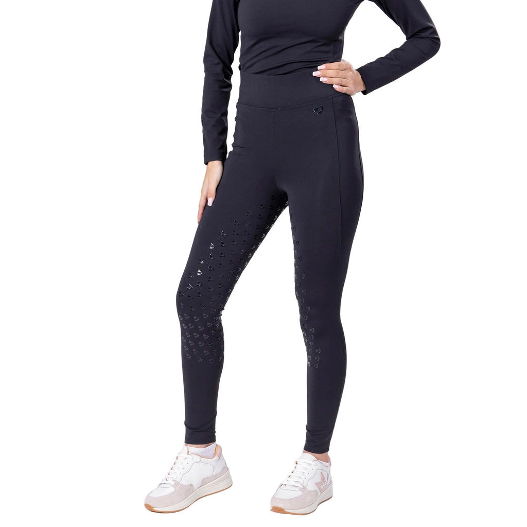 Person wearing black riding tights with subtle pattern on a white background