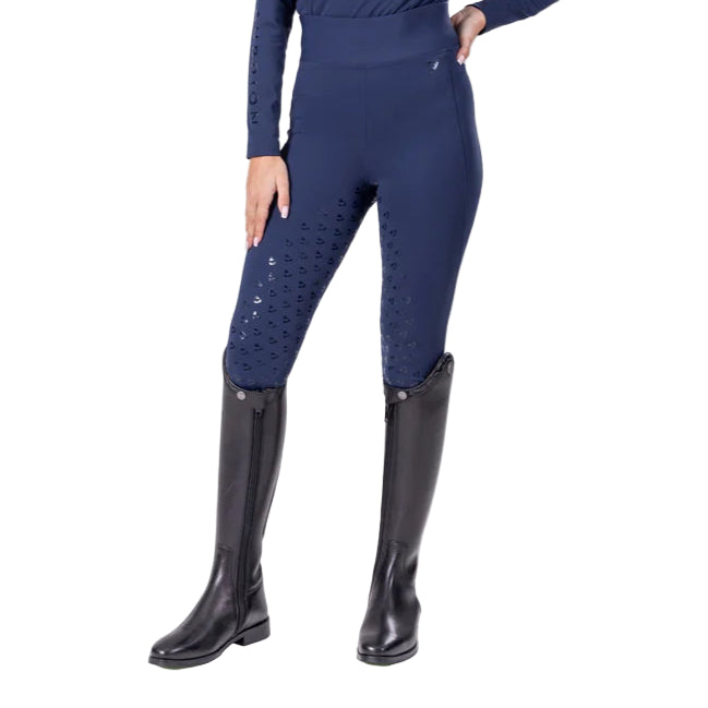 Person wearing navy riding pants with decorative elements and black riding boots on a white background